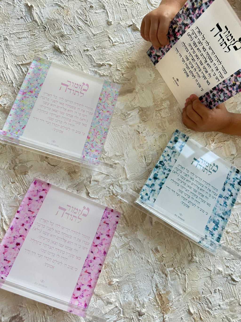 Mizmor LeToda — The Plexi Compact held in hand showing frame and artwork detail, hand-painted Hebrew psalm of gratitude
